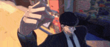 a man in a suit is holding a cigarette in his hand