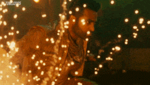 a man is standing in front of a fire with the date 2005 on the bottom left