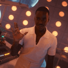 a man in a white shirt is giving a peace sign with his hand