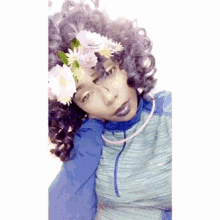 a woman with curly hair wearing a flower crown on her head