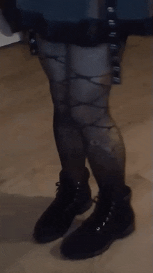 a person wearing a pair of black boots and tights