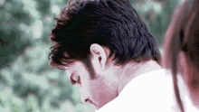 a close up of a man 's head with a woman behind him