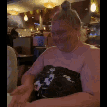 a woman in a floral dress is sitting at a table