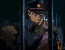a man in a hat is behind bars and pointing at the camera