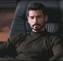 a man with a beard is sitting in a chair with the name sameh on the bottom