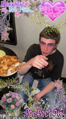 a man sitting at a table with a plate of food and a pink heart that says naughty but nice