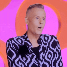 a man in a black and white jacket is making a face