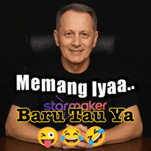 a man wearing a black shirt that says ' emang lyaa baru tau ya '