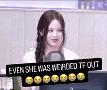 a woman is sitting in front of a microphone and a sign that says even she was weirded tf out
