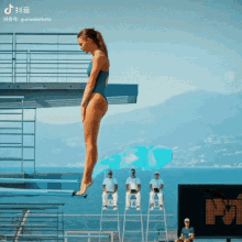 a woman in a blue swimsuit is jumping into the water