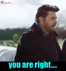 a man is standing in front of a car and says you are right .