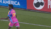 a cheez it sign is behind a soccer player in a pink jersey