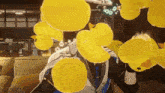 a man is surrounded by yellow rubber ducks on a couch