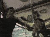 a man and a woman are standing in front of a carousel with the letter c on it