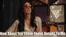 a woman wearing sunglasses sits at a table with a glass of wine and says how about you leave those details
