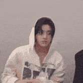 a man wearing a white hoodie with the word super on it