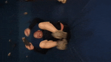 a man is laying on a blue mat with his legs crossed