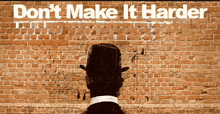 a man in a top hat stands in front of a brick wall with the words " don 't make it harder "