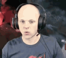 a bald man wearing headphones and a shirt with a cherry on it