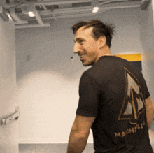 a man wearing a black shirt that says machzilla on the back