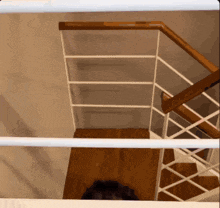 looking down a staircase with a white railing
