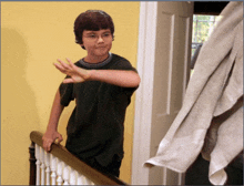 a young boy with glasses is standing on a staircase with his hand outstretched