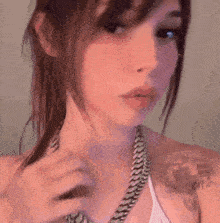 a close up of a woman 's face with a tattoo on her arm