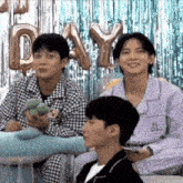 a group of young men are sitting next to each other in front of balloons that say day .