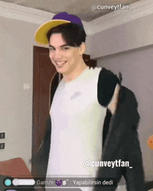 a man wearing a purple hat and a white shirt is standing in front of a screen that says @cunveytfan_