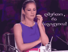 a woman sits in front of a microphone with her hand on her forehead and a sign that says ' lg '
