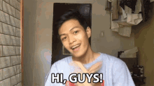 a young man is saying hi guys in front of a door
