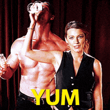 a shirtless man drinking from a glass next to a woman with the word yum in yellow