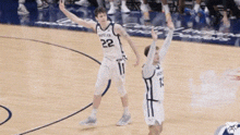 a basketball player with the number 22 on his jersey is celebrating