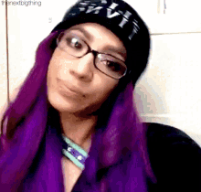 a woman with purple hair wearing glasses and a black hat