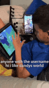 a boy is playing a video game on a tablet while holding a phone .