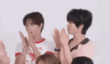 a group of young people are clapping their hands together .