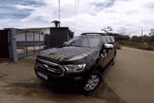 a black federal police vehicle is parked in front of a gate