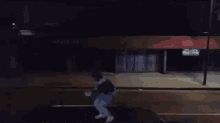 a man is jumping off the roof of a car in front of a building that says motel la