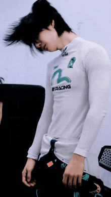 a man wearing a white shirt that says racing on the front of it