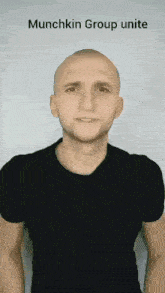 a bald man in a black shirt is smiling with the words munchkin group unite above him