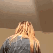 a person is holding a cell phone in their hand and their hair is being blown in the wind .
