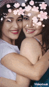 two women hugging each other with flowers on their faces