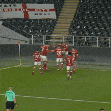 a group of soccer players on a field with a bet sign in the background