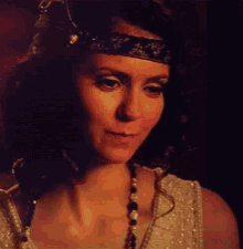 a woman wearing a headband and a pearl necklace