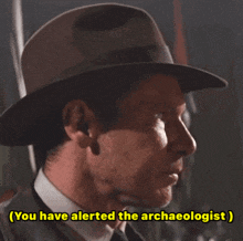 a man wearing a hat and tie says you have alerted the archaeologist