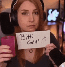 a woman in headphones is holding a sign that says bitti geld