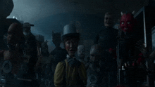 a man in a top hat is surrounded by a group of devils