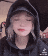 a girl wearing a hoodie and a hat is crying .