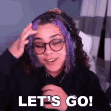 a girl with purple hair and glasses is wearing headphones and saying `` let 's go '' .