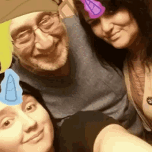 a man and two women are posing for a picture with a unicorn on their foreheads
